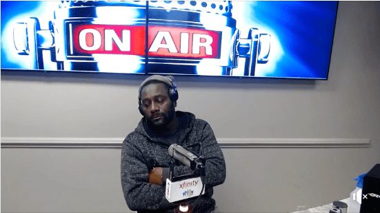 Man sitting in a radio studio with headphones and microphone.